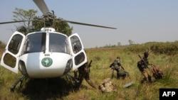 Ba rangers bazali kokita na hélicoptère na parc ya Garamba, na Ituri, RDC, 7 février 2016.