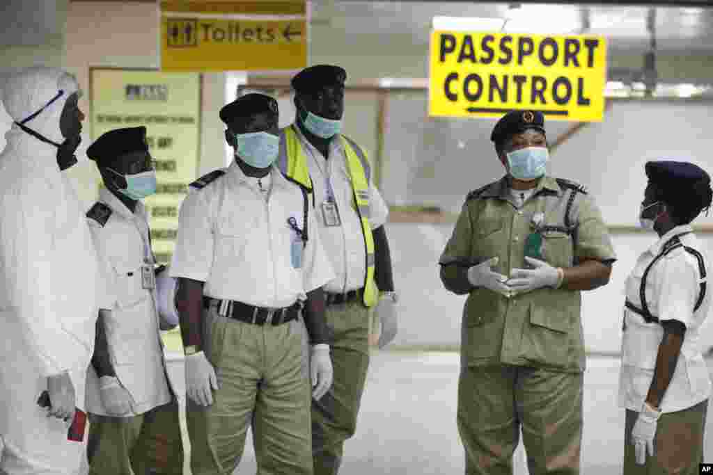 Nesta foto de 4 de Agosto, os funcionários da alfândega aguardam pelos passageiros, no Aeroporto Internacional&nbsp; Murtala Muhammed em Lagos, Nigéria.