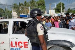 La Policía Nacional de Haití custodia la entrada a la Embajada de Estados Unidos mientras haitianos se reúnen el 10 de julio de 2021 para pedir asilo tras el asesinato del presidente Jovenel Moise.