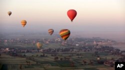 FILE - Hot air balloons fly over the west bank of the Nile River in Luxor, Egypt, April 1, 2016.
