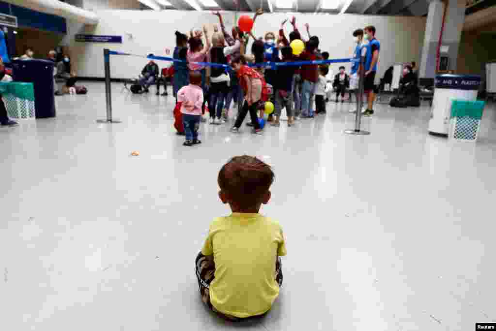 A child sits on the floor at Fiumicino Airport, as Afghan evacuees arrive in Italy following their trip from Kabul, in Rome, Italy.