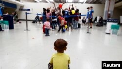 A child sits on the floor at Fiumicino Airport, as Afghan evacuees arrive in Italy following their journey from Kabul, in Rome, Italy.
