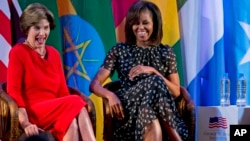 U.S. first lady Michelle Obama, right, and former U.S. first lady Laura Bush laugh as they participate in the African First Ladies Summit: “Investing in Women: Strengthening Africa,” hosted by the George W. Bush Institute, July 2, 2013, in Dar es Salaam, 