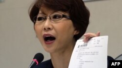 Chen Ting-fei, a lawmaker from the Democratic Progressive Party (DPP), displays a justice agreement signed between Taiwan and China to the press at Parliament in Taipei, April 12, 2016.