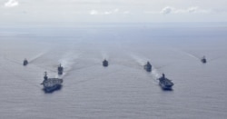 U.S. Navy ships from the Theodore Roosevelt Carrier Strike Group, the America Expeditionary Strike Group, and the U.S. 7th Fleet command ship, USS Blue Ridge, transit the Philippine Sea, March 24, 2020.
