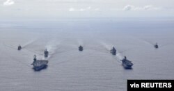 U.S. Navy ships from the Theodore Roosevelt Carrier Strike Group, the America Expeditionary Strike Group, and the U.S. 7th Fleet command ship, USS Blue Ridge, transit the Philippine Sea, March 24, 2020.