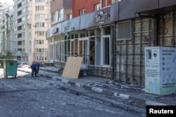 Un hombre recoge vidrios rotos junto a un edificio alcanzado por un bombardeo, lo que las autoridades locales llamaron un ataque militar ucraniano, en el curso del conflicto Rusia-Ucrania en Belgorod, Rusia, el 9 de mayo de 2024. REUTERS/Stringer