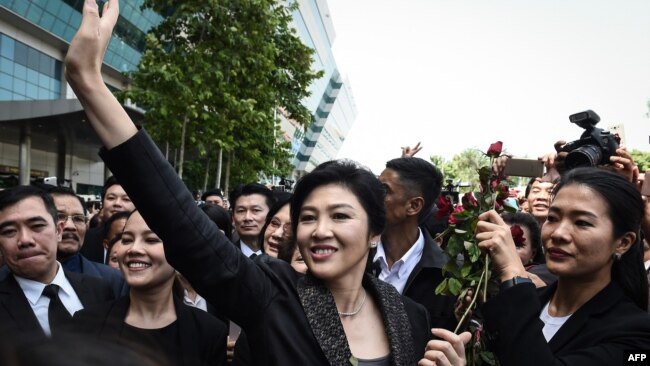 FILE - Former Thai prime minister Yingluck Shinawatra waves to supporters as she leaves the Supreme Court in Bangkok on Aug. 1, 2017. Thailand's Supreme Court on Monday cleared her of corruption in awarding a government contract during her time in office.