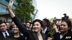 แฟ้มภาพ - อดีตนายกฯ ยิ่งลักษณ์ ชินวัตร โบกมือให้กลุ่มผู้สนับสนุน ขณะเดินทางออกจากศาลฎีกาเมื่อ 1 สิงหาคม 2560