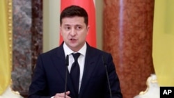 FILE - Ukrainian President Volodymyr Zelenskiy speaks during a news briefing in Kyiv, Oct. 12, 2020.