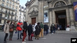 Church-goers wearing face masks as a precaution against the coronavirus lineup outside the Notre-Dame-des-Champs church in Paris, Sunday, Nov. 29, 2020. 