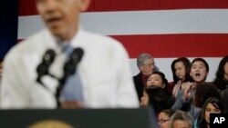 Un inmigrante surcoreano grita en el fondo al presidente Obama, pidiendo que pare las deportaciones.