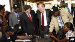 Independent Electoral and Boundaries Commission’s, IEBC, U.S. Ambassador to Kenya, Robert F. Godec, second right and British High Commissioner to Kenya, Christian Turner, second left, inside the voter registration centre in Thika Nairobi Kenya, Dec. 15, 2