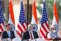 FILE - U.S. Secretary of Defence Mark Esper addresses the media next to U.S. Secretary of State Mike Pompeo and India's Defence Minister Rajnath Singh during a joint news conference in New Delhi, India, Oct. 27, 2020.