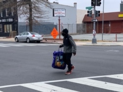 A man crosses a quiet street in Washington's Park View neighborhood. (Chris Simkins/VOA)