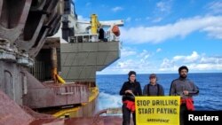 FILE —Greenpeace activists stand with a banner on a Shell oil production vessel in the Atlantic Ocean, February 1, 2023. 