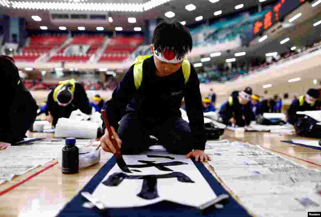 A boy participates in a New Year calligraphy contest at Nippon Budokan in Tokyo, Japan.