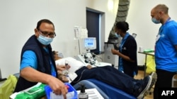 Aubrey Dhanraj, a plasma donor lies on reclining seat to give convalescent plasma for coronavirus treatment at a newly opened plasma donor center in Twickenham, southwest London on June 11, 2020. 