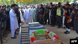 Security officials attend the funeral prayers for a policeman who was killed along with a polio worker in an attack by gunmen in Bajaur district, Khyber Pakhtunkhwa province, Pakistan, Sept. 11, 2024.