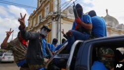 Armed pro-government militia members flash victory signs as they occupy the Monimbo neighborhood of Masaya, Nicaragua, July 18, 2018. 