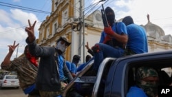 Armed pro-government militia members flash victory signs as they occupy the Monimbo neighborhood of Masaya, Nicaragua, July 18, 2018. 