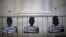 FILE - Cut-out depicting victims of human rights abuse during the rule of former dictator Augusto Pinochet hang on a fence next to the "La Moneda" Presidential Palace during a rally in Santiago, Sept. 11, 2015. 