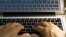 FILE - Hands type on a computer keyboard in Los Angeles, Feb. 27, 2013.