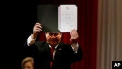 El presidente de Paraguay, Horacio Cartes, muestra el certificado que lo declara senador electo, durante una ceremonia en Asunción, Paraguay, el viernes 25 de mayo de 2018. 