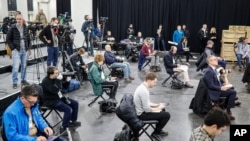 FILE - Journalists practice social distancing during a news conference with New York Gov. Andrew Cuomo at the Jacob Javits Center, which housed a temporary hospital in response to the COVID-19 outbreak, March 24, 2020, in New York.