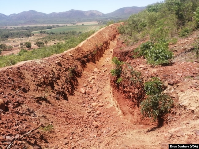 In this photo taken on Dec. 11, 2024 shows a large trench dug around the Sino Huijing Mine mountain to prevent rocks from rolling into the residents homes.