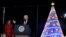 President Donald Trump speaks as first lady Melania Trump listens during the lighting ceremony for the 2017 National Christmas Tree on the Ellipse near the White House in Washington, Nov. 30, 2017. 