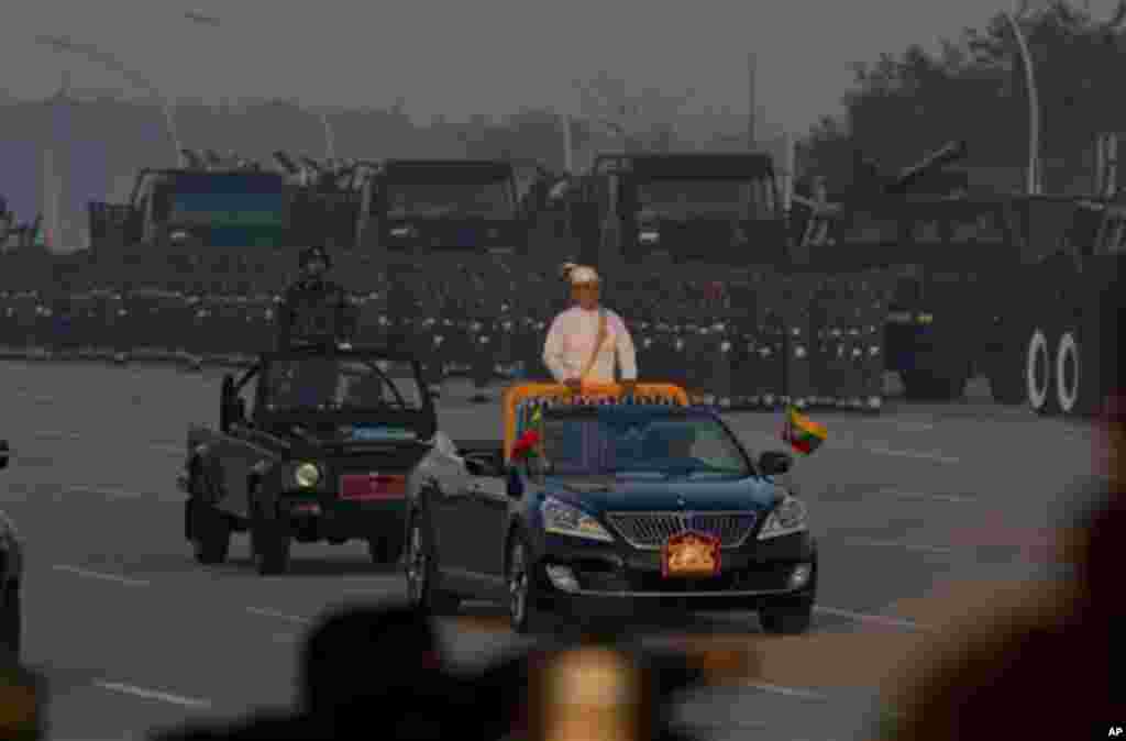 Myanmar President Thein Sein, center, rides in an open vehicle inspecting officers and military hardware during a ceremony to mark Myanmar's 67th anniversary of Independence Day in Naypyitaw, Myanmar, Sunday, Jan. 4, 2015. (AP Photo/Gemunu Amarasinghe)