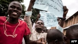 Des manifestants brandissent des pancartes lors d'une marche Kinshasa le 12 janvier 2018.