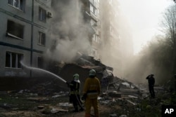 Firefighters work at the scene where a residential building was heavily damaged after a Russian attack in Zaporizhzhia, Ukraine, on October 9, 2022. (Leo Correa/AP)