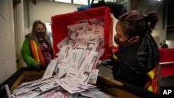 FILE - Election worker Kristen Mun empties ballots from a ballot box in Portland, Oregon, on Nov. 3, 2020. Newly declassified intelligence says the Kremlin believes it has had success in disrupting the past two U.S. presidential elections.