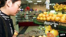 Seorang konsumen China mengamati buah limau gedang yang diimpor dari Florida, AS pada sebuah supermarket di Beijing (foto: ilustrasi). 