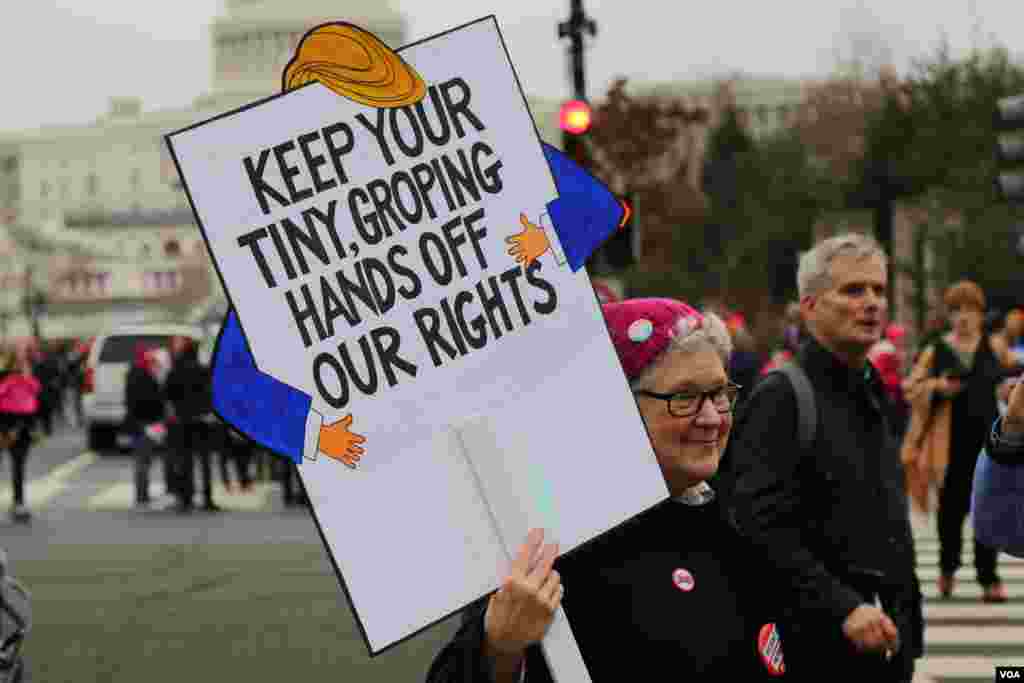 Protesters hold up signs ahead of the Women's March on Washington in downtown Washington, D.C., one day after Donald Trump's inauguration as President of the United States of America. January 21, 2017 (B. Allen / VOA)