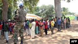 Un soldat monte la garde près d'anciens enfants soldats anti-Balaka attendant d'être libérés d'un camp à Batangafo, en République centrafricaine, 28 août 2015. 