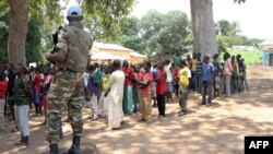 Un soldat monte la garde près d'anciens enfants soldats anti-Balaka attendant d'être libérés d'un camp à Batangafo, en République centrafricaine, 28 août 2015. 