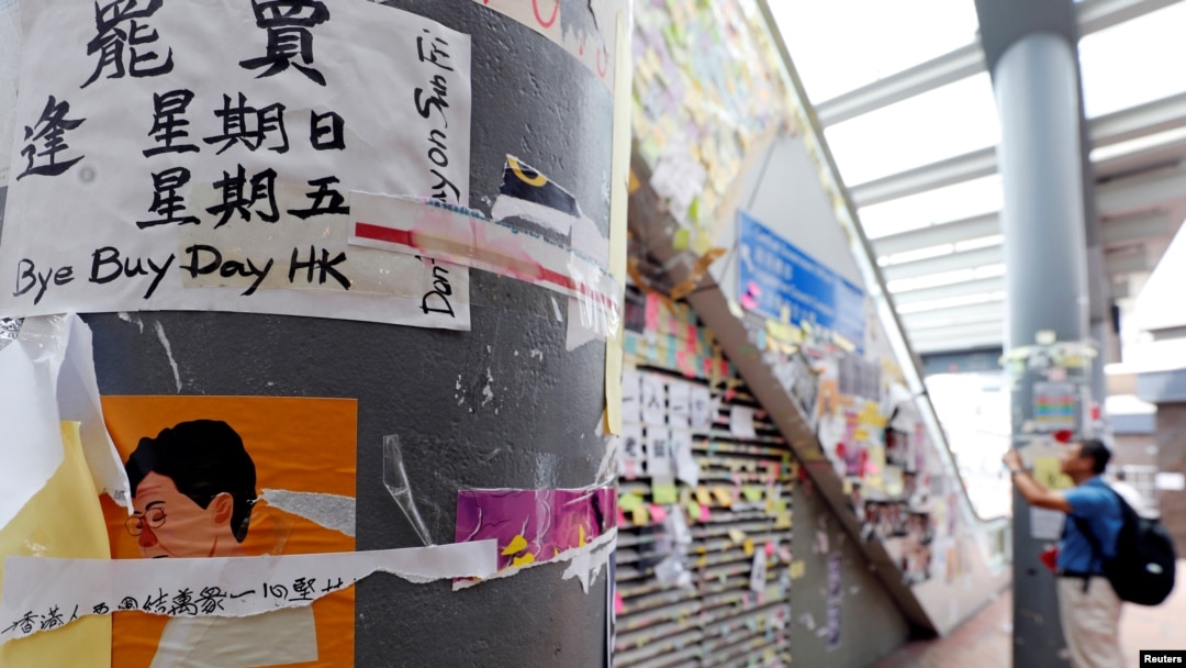 Seorang pria mengabadikan poster-poster dan stiker-stiker berisi dukungan terhadap gerakan anti-pemerintah dekat Kantor Pemerintah Pusat di Hong Kong, China, 5 September 2019. (Foto: Reuters)