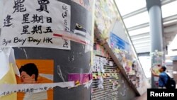 Seorang pria mengabadikan poster-poster dan stiker-stiker berisi dukungan terhadap gerakan anti-pemerintah dekat Kantor Pemerintah Pusat di Hong Kong, China, 5 September 2019. (Foto: Reuters)