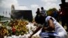 A woman lights a candle at a memorial outside the Presidential Palace in memory of slain President Jovenel Moise, in Port-au-Prince, Haiti, July 14, 2021, a week after Moise was assassinated at his home.