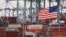 Chinese shipping containers are stored beside a U.S. flag after they were unloaded at the Port of Los Angeles in Long Beach, California, May 14, 2019. 