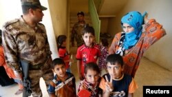 Civilians, who fled their homes due to the clashes on the outskirts of Falluja, gather in the town of Garma, Iraq, May 30, 2016. 