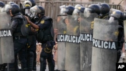 ARCHIVO - La policía hace guardia en una barricada mientras los partidarios del derrocado presidente Pedro Castillo protestan en Lima, Perú, el lunes 12 de diciembre de 2022. 