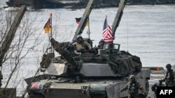 Американські солдати на танку Abrams і німецькі солдати беруть участь у військових навчаннях НАТО DRAGON-24 у Корженево, північна Польща, 4 березня 2024 року.