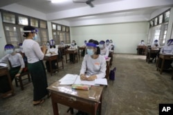 FILE - A teacher and students wearing face shields and masks attend a class at a high school in Yangon, Myanmar, on July 21, 2020. Student enrollment in Myanmar dropped 80% from the beginning of the COVID-19 pandemic in 2020 through 2022, a year after the military took over.