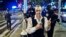 FILE - A reveler gets his picture taken by a friend in front of heavily armed police during the Greenwich Village Halloween Parade in New York. The NYPD says thousands of uniformed and plainclothes officers will patrol the 2018 parade in Greenwich Village, Oct. 31, 2017. 