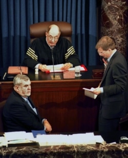 FILE - Supreme Court Chief Justice William Rehnquist reads the vote tally in the Senate's impeachment trial of President Clinton, as Clinton's attorney Charles Ruff (L) listens, February 12, 2019. The Senate rejected both counts.