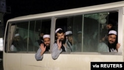 FILE - Newly freed Taliban prisoners are seen inside a bus at Bagram prison, north of Kabul, Afghanistan, April 11, 2020.